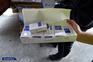 Funkcjonariusze CBŚP z Gdańska i KAS, a także zabezpieczone papierosy w kontenerze.