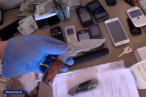 Policjant CBŚP trzymający zabezpieczony nóż