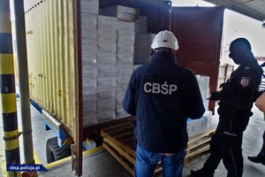 Funkcjonariusze CBŚP z Gdańska i KAS, a także zabezpieczone papierosy w kontenerze.