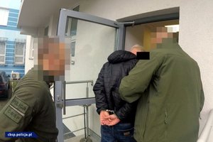 Policjanci CBŚP prowadzą osoby zatrzymane