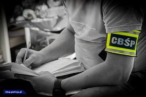 policjant CBŚP wypełniający dokumentację służbową
