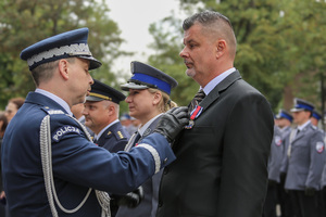 Zastępca komendant głównego Policji wręcza medal mężczyźnie.
