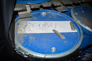 Metalowa beczka z napisem &quot;odpad&quot;.