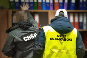 zdjęcie ilustracyjne - funkcjonariusze cbśp i kas obok regału z segregatorami