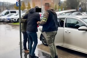 funkcjonariusze prowadzą osobę