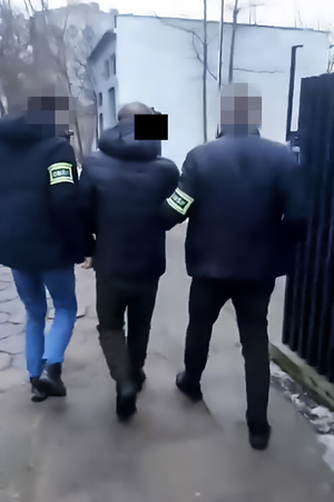 policjanci prowadzą zatrzymanego